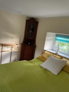 Un dormitorio con una cama verde y una ventana en Schneewittchens Haus 