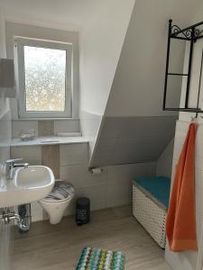 baño con lavabo y aseo y ventana en Schneewittchens Haus 