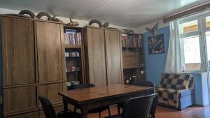 uma sala de estar com uma mesa e algumas prateleiras de livros em Doxturi's sakhli em Shatili