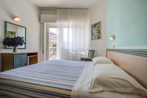 Un dormitorio con una cama grande y una ventana en Hotel San Giorgio, en Milano Marittima