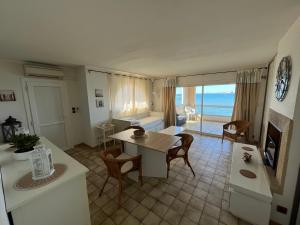 a kitchen and living room with a table and chairs at La Maison de la Mer - 1er Étage in Fos-sur-Mer