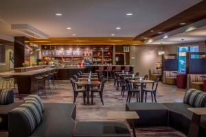 a restaurant with tables and chairs and a bar at Courtyard Greensboro Airport in Greensboro