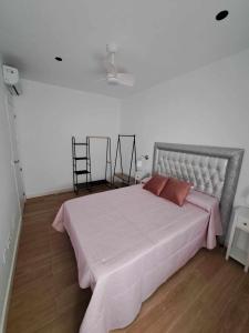 um quarto com uma cama grande e um cobertor rosa em Piso Jaén Parque em Jaén
