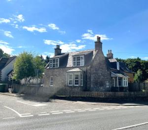 an old stone house on the side of the street at Altonhill House - room only in Nairn