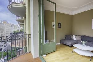 uma sala de estar com um sofá e uma varanda em Ola Living Aribau Apartments em Barcelona