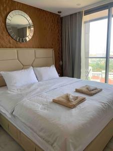 um quarto com uma cama grande com duas toalhas em Copacabana Pattaya em Praia de Jomtien