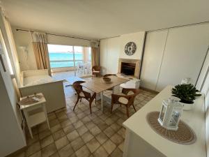 a kitchen and dining room with a table and a living room at La Maison de la Mer - 1er Étage in Fos-sur-Mer