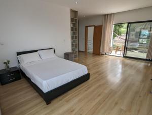 sypialnia z dużym łóżkiem i drewnianą podłogą w obiekcie Finca Pedra Molar w mieście Órgãos