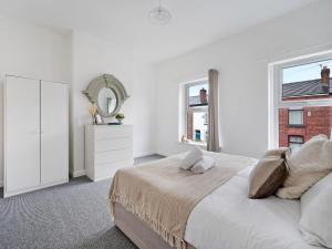 - une chambre blanche avec un lit et un miroir dans l'établissement Pass the Keys Cheerful 3 bed home in Manchester suburbs, à Manchester