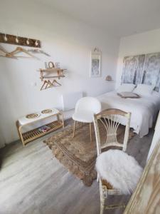 um quarto com uma cama, uma cadeira e uma mesa em Au Poème du Chêne, Logement indépendant, Intimité, SPA et bien-être em Basse-Goulaine
