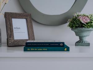 dois livros numa prateleira com uma fotografia e um vaso em Pass the Keys Cheerful 3 bed home in Manchester suburbs em Manchester
