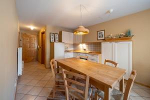a kitchen with a wooden table and chairs at Ciasa Buro - Thaus in Moena +6 photos