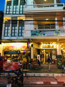 a building with people walking in front of it at Thunyaporn Hostel in Trang