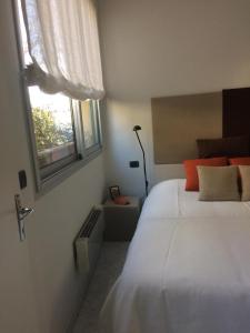 - une chambre avec un grand lit blanc et une fenêtre dans l'établissement Appartamento "Renata" in residence Cap Roux Eze Borde de Mer Costa Azzurra, à Èze