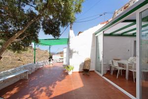 - une terrasse avec une table et des chaises dans un bâtiment dans l'établissement Casa Cueva Tejeda 2 dorm, à Tejeda
