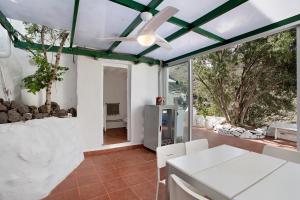 uma sala de estar com uma ventoinha de tecto e uma mesa em Casa Cueva Tejeda 2 dorm em Tejeda