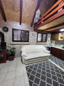 ein Wohnzimmer mit einer weißen Couch in einer Küche in der Unterkunft Cottage in Apatin