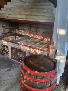 a wooden barrel sitting in front of a fireplace at Cottage in Apatin