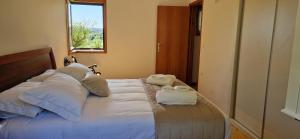a bedroom with a bed with towels on it at Quinta da Caselinha in Paredes de Coura