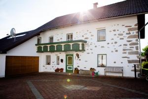 a white house with a green door and a brick driveway at Ferienhaus Drasch in Lalling