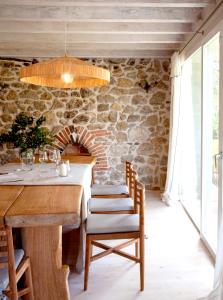 ein Esszimmer mit einem Tisch und einer Steinwand in der Unterkunft Wishome-Casa con piscina climatizada, cerca Comillas in Valdaliga 