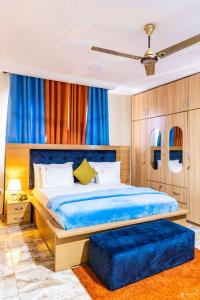 a bedroom with a blue bed and a blue ottoman at Richjoy Lodge in Tema