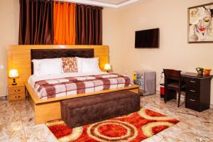 a bedroom with a bed and a desk with a computer at Richjoy Lodge in Tema