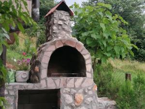 Zaovine的住宿－Vikendica moonlight，花花园里的石头比萨饼烤箱