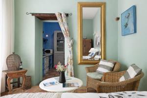 een woonkamer met een spiegel en een tafel en stoelen bij El Piccolo in Mácher