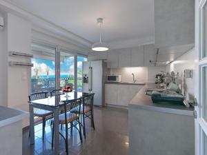 a kitchen and dining room with a table and chairs at Varkiza sea view apartment in Vari