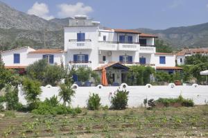 una grande casa bianca con montagne sullo sfondo di Villa Maria a Marathokampos