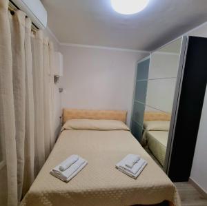 Un pequeño dormitorio con una cama con toallas. en Tiny Little Home - Casa Vacanze ad Uso Esclusivo, en Nápoles