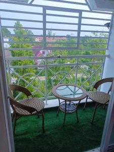 een tafel en stoelen op een balkon met uitzicht bij 3rd floor apartment with 2 bedroom and no elevator in Kota Bharu