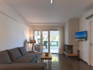 a living room with a couch and a fireplace at Varkiza sea view apartment in Vari