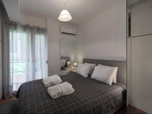 a bedroom with a bed with towels on it at Varkiza sea view apartment in Vari