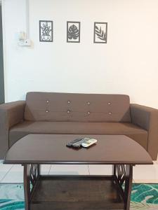 a brown couch with a coffee table in a living room at 3rd floor apartment with 2 bedroom and no elevator in Kota Bharu