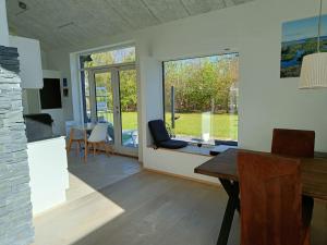 eine Küche und ein Wohnzimmer mit einem Tisch und einem Fenster in der Unterkunft Silkeborg Legoland luxury cabin in Silkeborg