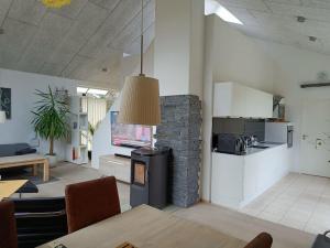 a kitchen and living room with a stone fireplace at Silkeborg Legoland luxury cabin in Silkeborg