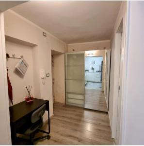 einen Flur mit einem Schreibtisch und einer Tür zu einem Zimmer in der Unterkunft Tiny Little Home - Casa Vacanze ad Uso Esclusivo in Neapel