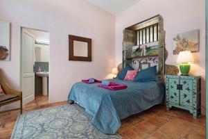 a bedroom with a bed with a blue comforter at El Cello in Mácher