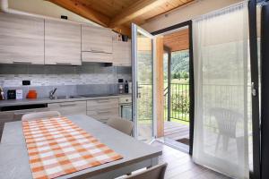 uma cozinha com uma mesa e uma porta de vidro deslizante em Agriturismo L'isola del Cavallo 2 em Desco