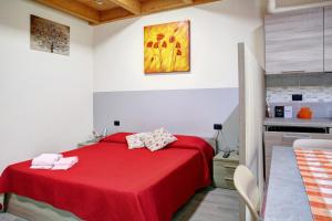 um quarto com uma cama vermelha e uma cozinha em Agriturismo L'isola del Cavallo 2 em Desco
