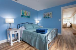 um quarto com paredes azuis e uma cama com lençóis azuis em NEW Listing! Centrally Located Property! Close to Everything! em Jacksonville Beach
