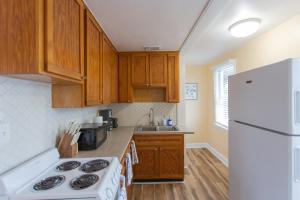 a kitchen with wooden cabinets and a white refrigerator at NEW Listing! Centrally Located Property! Close to Everything! in Jacksonville Beach