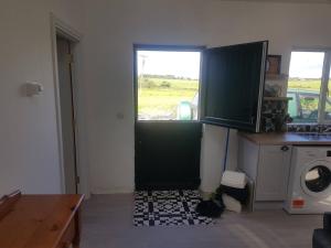 a kitchen with a green door and a window at Lavender lane cottage in Tralee