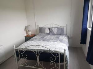 a bedroom with a bed with blue and gray pillows at Lavender lane cottage in Tralee