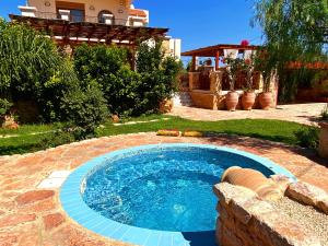 a small swimming pool in a yard with a house at Lucidum Rhodian Gastronomy Villa in Faliraki