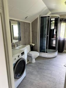 uma casa de banho com uma máquina de lavar roupa e um WC em Søre Osen Ørbekken em Midskogberget