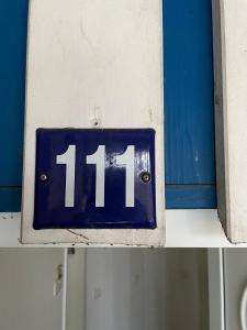 a blue sign with the number on a wall at Seeblick Wohnung 111 mit Ostseeblick in Ostseebad Koserow