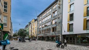 a cobblestone street in a city with buildings at Nice studio apartment on a pedestrian street in Helsinki